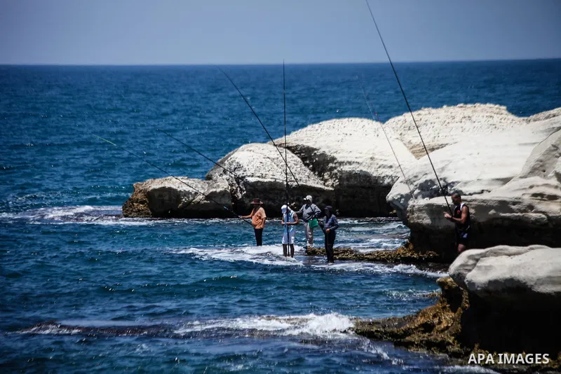 Tourists fish at the Mediterranean Sea in the Al-Naqoura area, southern Lebanon, near the Lebanese Israeli border, 05 July 2013. Al-Naqoura is a geologic formation, located on the coast of the Mediterranean Sea, in the W...