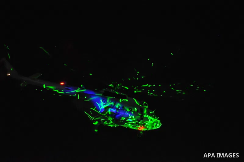 An Egyptian army helicopter is lit with laser type beams from protesters on the ground, as hundreds of thousands Egyptians flood Egypt's landmark Tahrir square to demonstrate against ousted President Mohammed Morsi and i...