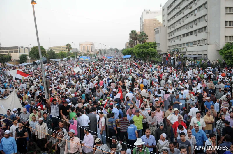 Ousted President Mohamed Morsi supporters and Muslim brotherhood members shout political and hold placards in his support as they demonstrate against his toppling at Raba al-Adawyia mosque on July 7, 2013 in Cairo. Carry...
