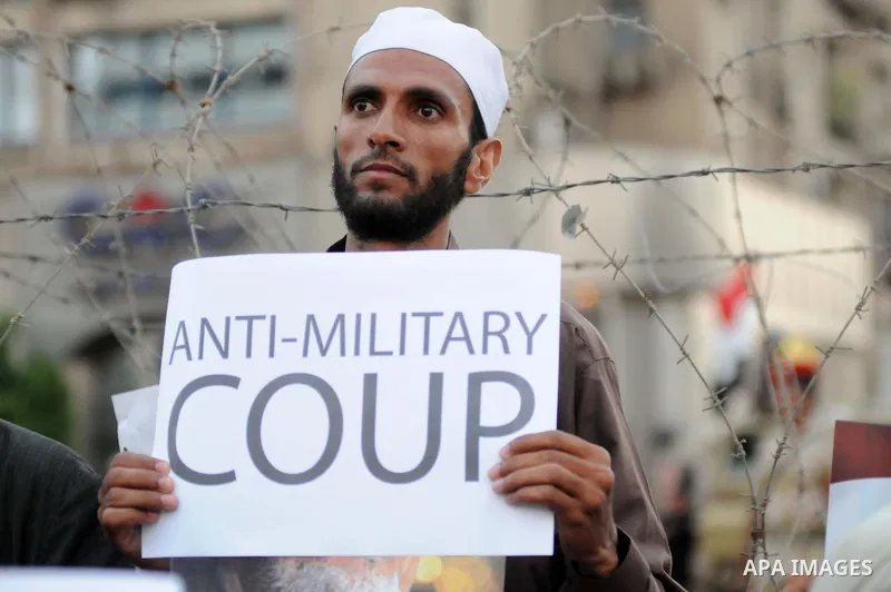 Ousted President Mohamed Morsi supporters and Muslim brotherhood members shout political and hold placards in his support as they demonstrate against his toppling at Raba al-Adawyia mosque on July 7, 2013 in Cairo. Carry...