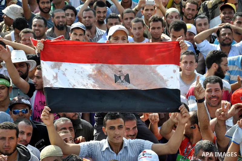 An Egyptian supporter of the ousted President Mohammed Mursi waves a flag stained with blood flutters during a rally at the Raba El-Adwyia square where they are camping in Cairo July 8, 2013. At least 51 people were kill...