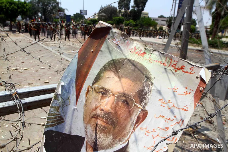 A poster of deposed president Mohamed Morsi hangs on barbed wire that blocks the access to the headquarters of the Republican Guard in Cairo on July 9, 2013. Egypt's armed forces warned in a statement against any attempt...