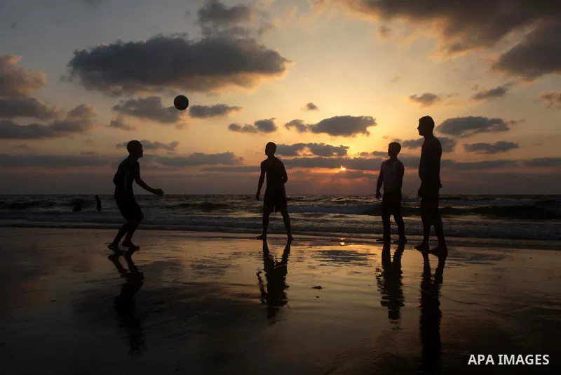 Palestinians enjoy playing the football in the sea at Gaza beach on July 9, 2013. ahead of the Muslim holy fasting month Ramadan. Photo by Ashraf Amra