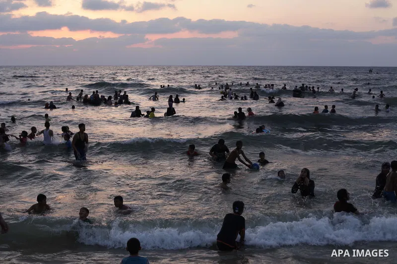 Palestinians enjoy swimming in the sea at Gaza beach on July 9, 2013.ahead of the Muslim holy fasting month Ramadan. Photo by Ashraf Amra