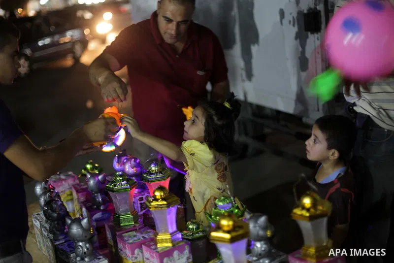 A Palestinian child buys the traditional Ramadan lanterns at a street in Gaza City, on July 9, 2013, ahead of the Muslim holy fasting month. Photo by Ashraf Amra