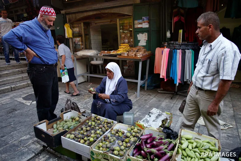A Palestinian woman sells fruits and vegetables during the first day of the holy fasting month of Ramadan, at a street marke in Jerusalem on July 10, 2013. Photo by Saeed Qaq