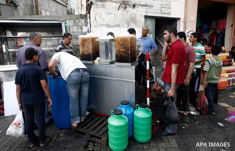 A Palestinian man sells carob juice at during the first day of the holy fasting month of Ramadan, at a street marke in Gaza city on July 10, 2013. Photo by Emad Nassar