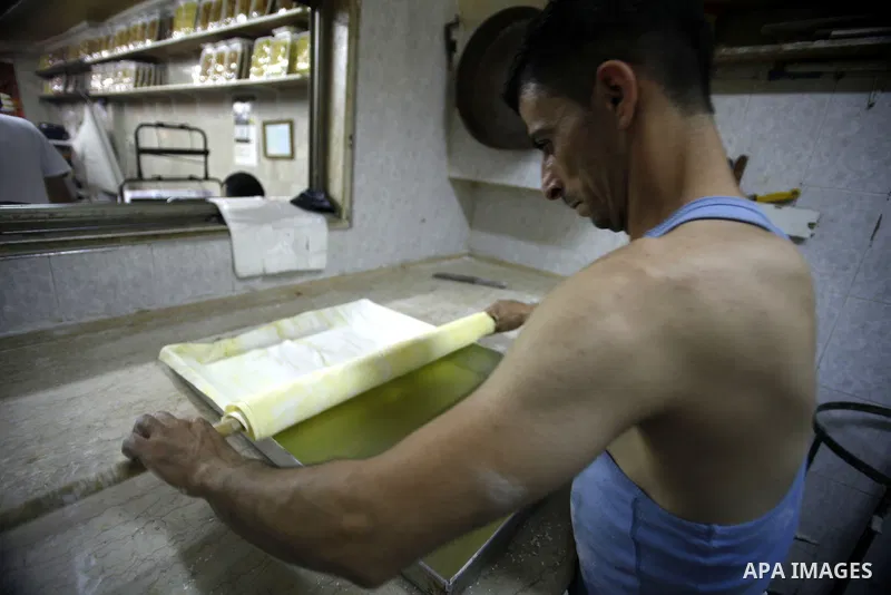 A Palestinian man prepares traditional sweets "Baklava" during the fourth day of the holy fasting month of Ramadan, in Jerusalem old city, on July 13, 2013. Muslims around the world are observing the holy fasting month o...