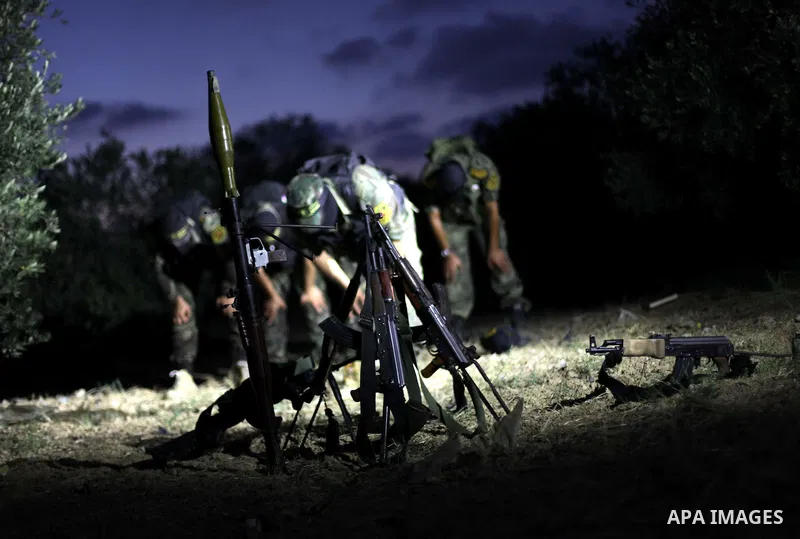 Masked militants of the Al Quds Brigades, the armed wing of the Islamic Jihad organization pray Maghrib prayer during a guard the eastern border of Gaza City, on July 15, 2013. Photo by Ashraf Amra