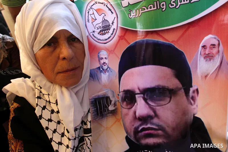 Palestinians hold pictures of prisoners held in Israeli jails during a protest outside Red Cross office in Gaza City, on July 22, 2013 in solidarity with Palestinian prisoners held by Israel to demand their release. Phot...
