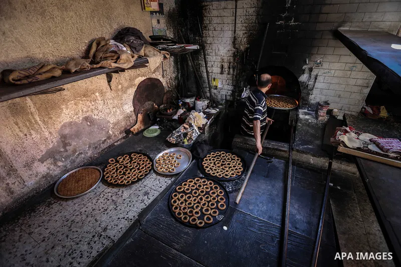 A Palestinian baker bakes cookies at his traditional bakery during the Muslim fasting month of Ramadan, in Khan Younis, in southern Gaza strip, Aug 04, 2013. Ramadan is the holiest month in the Muslim calendar, during wh...