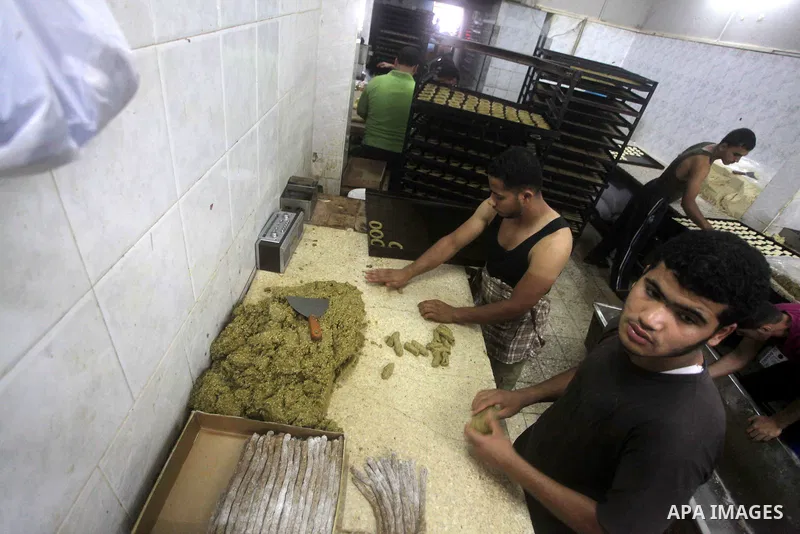 Palestinian vendors prepares date-filled mini cakes traditional for the Eid al-Fitr, at his shop in Gaza City on Aug. 5, 2013. as Muslims the world over prepare to celebrate Eid al-Fitr, starting with the with the sighti...