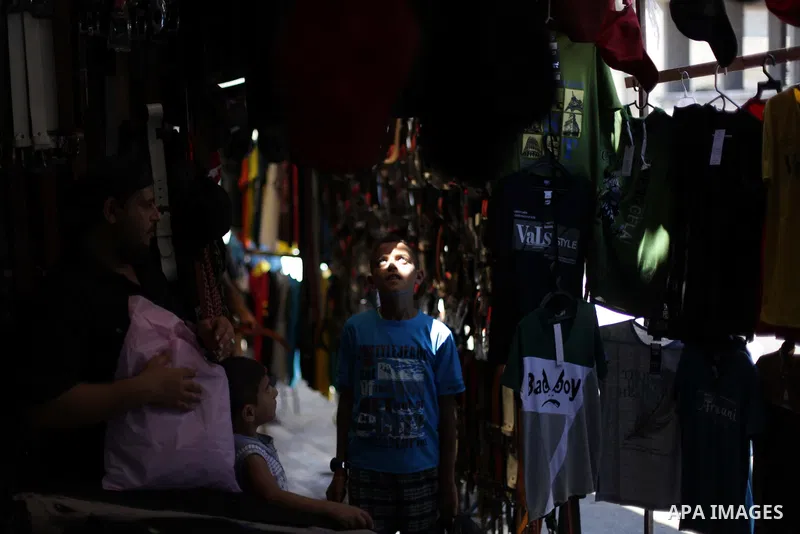 A Palestinian vendor displays the clothes at the main market during preparations for the Eid Al-Fitr feast Gaza city on Aug 06, 2013, as Muslims over the world prepare to celebrate Eid al-Fitr, a three day holiday markin...
