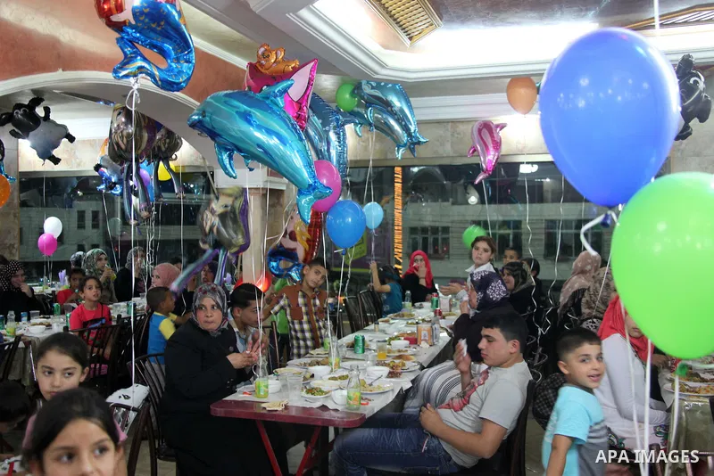 Palestinian orphans attend the Iftar ceremony (the evening meal during the Islamic month of Ramadan) to break their fasting in the West Bank city of Hebron, on Aug. 06, 2013. Photo by Mamoun Wazwaz