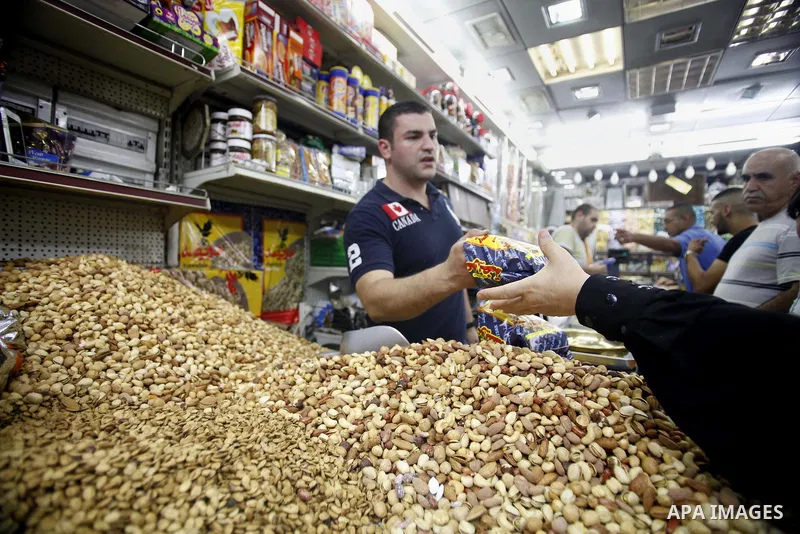 A Palestinian man sells nuts at a street market during preparations for the upcoming Eid al-Fitr festival which is celebrated at the end of holy fasting month of Ramadan, in Jerusalem city Aug 06, 2013, as Muslims over t...