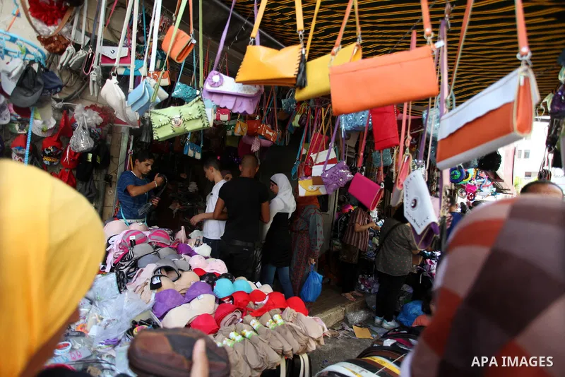 Palestinians shop during preparations for the Eid Al-Fitr feast at the market in the west bank city of Ramallah on Aug 07, 2013, as Muslims over the world prepare to celebrate Eid al-Fitr, a three day holiday marking the...