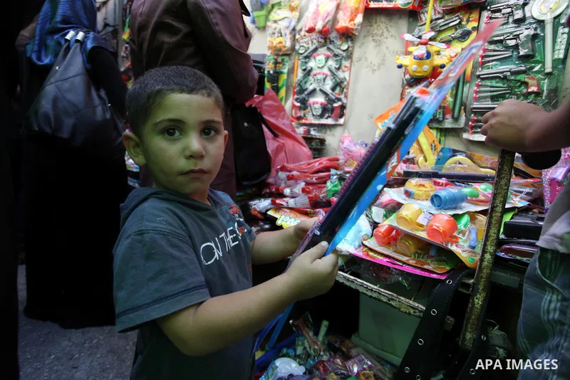 Palestinians shop during preparations for the Eid Al-Fitr feast at the market in the west bank city of Ramallah on Aug 07, 2013, as Muslims over the world prepare to celebrate Eid al-Fitr, a three day holiday marking the...