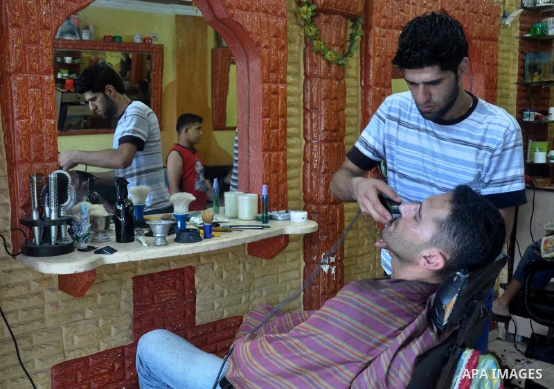 A Palestinian barber cuts hair for youths at a shop during preparations for the Eid Al-Fitr feast in Gaza city on Aug 07, 2013, as Muslims over the world prepare to celebrate Eid al-Fitr, a three day holiday marking the...