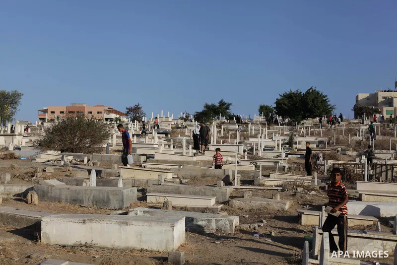 Palestinians visit their relatives' graves in a cemetery during the first day of Eid al-Fitr in Gaza City on August 8, 2013. Muslims around the world are celebrating Eid al-Fitr this week, marking the end of holiest mont...