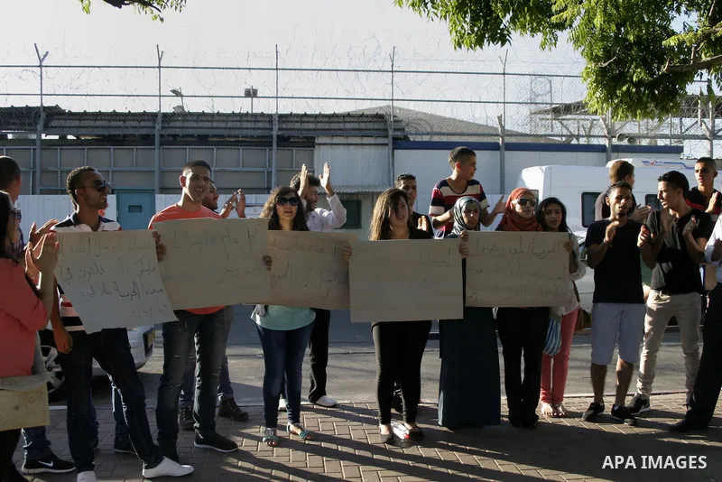 Palestinian Youth take part in a protest on the first day of Eid al-Fitr during a solidarity with Palestinian prisoners in Israeli jails, in front of Ramle prison in the city of Jerusalem, on Aug. 08, 2013. Photo by Saee...