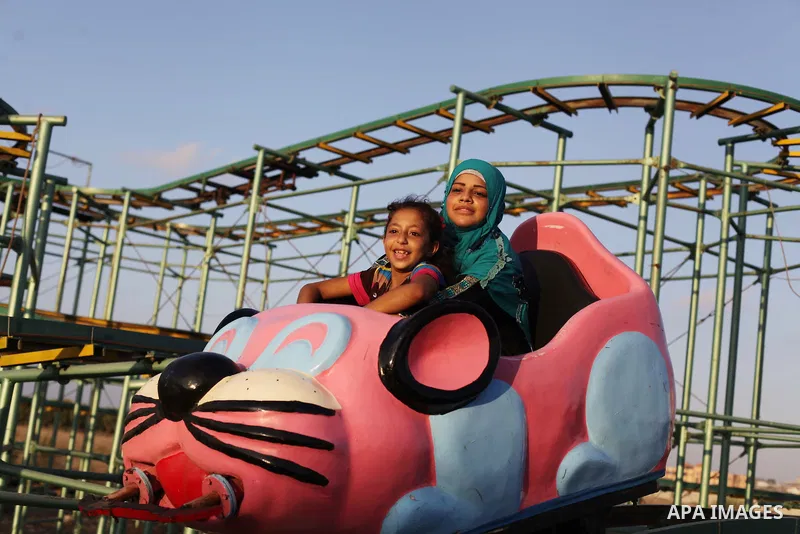 Palestinians enjoy a ride in an amusement park on the third day of Eid al-Fitr, marking the end of Islam's fasting holy month of Ramadan, in Gaza City on August 10, 2013. Photo by Ashraf Amra