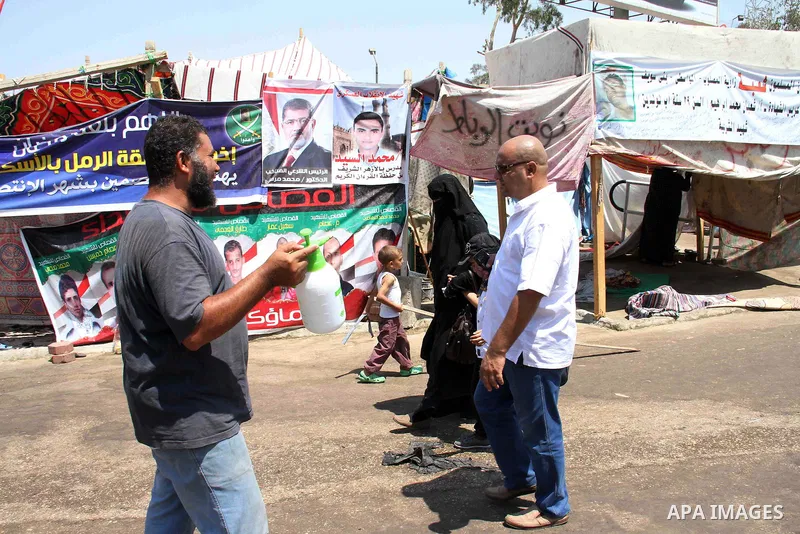 Members of the Muslim brotherhood and supporters of ousted Egyptian President Mohammed Morsi attend a sit-in outside the Rabaa al-Adawiya mosque in cairo on August 11, 2013. Morsi supporters hunker down behind makeshift...