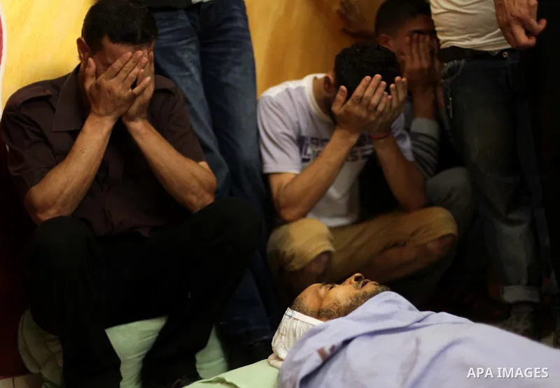 Palestinian mourners gather around the body of Hussein Awadullah, 32, during his funeral in Gaza City on Aug. 11, 2013. Awadullah was killed in an Israeli operation on the border with Gaza on Saturday night. Photo by Ash...