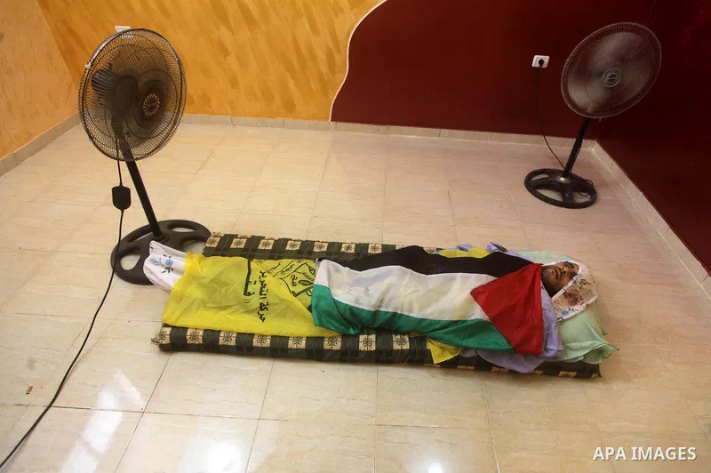Palestinian relatives of Hussein Awadullah, 32, grieve during his funeral in the Nuseirat Refugee Camp, southern Gaza Strip, Sunday, Aug. 11, 2013. Awadullah was killed in an Israeli operation on the border with Gaza on...