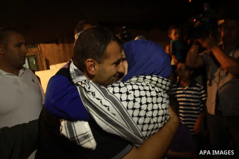 A released Palestinian prisoner Hosni Sawalha, is welcomed upon his arrival to his family house in Azmout village near Nablus in the West Bank .Wednesday, Aug. 14, 2013. Israel released 26 Palestinian inmates, including...