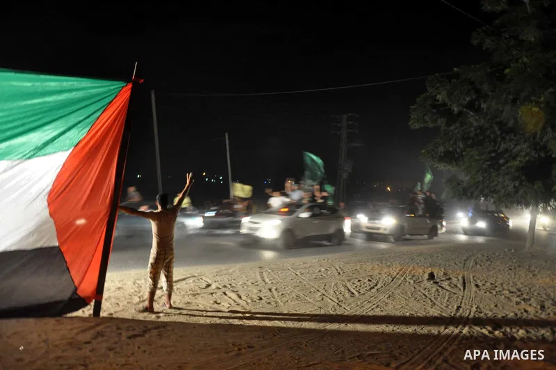Palestinian people greet and celebrate freed Palestinian prisoners who arrive in a bus at the Erez crossing, between Israel and Gaza in the Northern Gaza Strip, 14 August 2013. Israel released 26 long-held Palestinian pr...