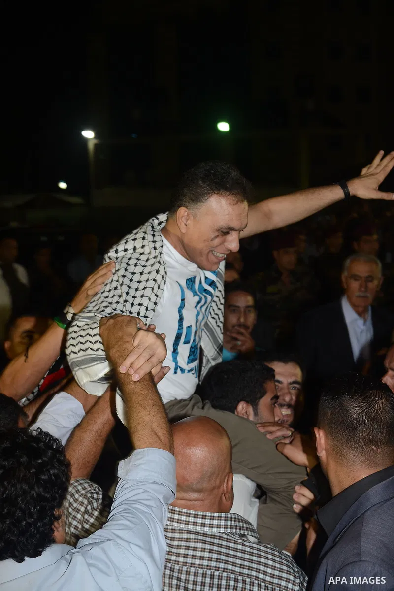 Palestinian people greet and celebrate freed Palestinian prisoners who arrive to the West Bank city of Ramallah early August 14, 2013. Israel freed 26 Palestinian prisoners on Wednesday to keep U.S.-sponsored peacemaking...