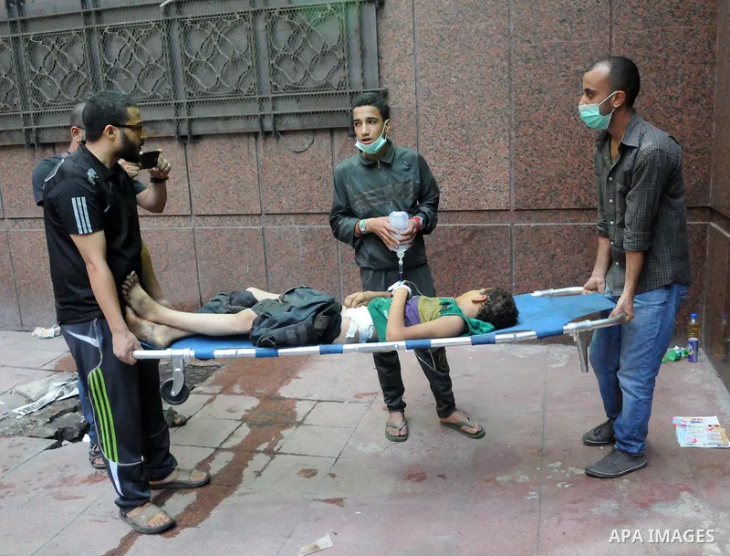 Egyptians treat an injured protester during clashes with Egyptian security forces in Ramses square, in downtown Cairo, Egypt, Friday, Aug. 16, 2013. Heavy gunfire rang out Friday throughout Cairo as tens of thousands of...