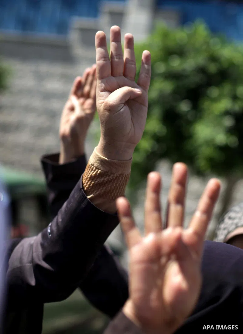 Palestinians hold up four fingers, a sign that protesters say symbolizes the Rabaah al-Adawiya mosque in Cairo, while waving an Egyptian flag during a protest supporting Egypt's ousted President Mohammed Morsi, in front...