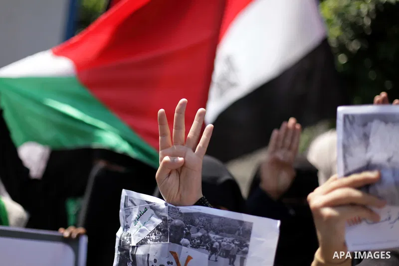 Palestinians hold up four fingers, a sign that protesters say symbolizes the Rabaah al-Adawiya mosque in Cairo, while waving an Egyptian flag during a protest supporting Egypt's ousted President Mohammed Morsi, in front...