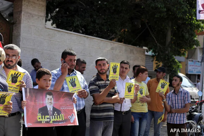Palestinians protester carry a placard and gestures during a rally in support of ousted Egyptian president Mohamed Morsi, in Gaza City on August 20, 2013. Egypt closed its Rafah border crossing in Sinai with the Palestin...