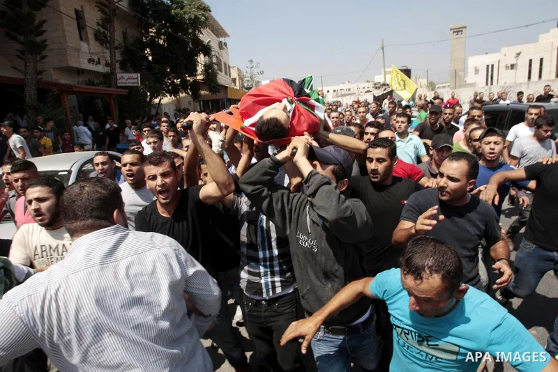 Palestinian mourners carry the body of Majd Lahlouh during his funeral at Jenin refugee camp in the West Bank city of Jenin on August 20, 2013. Israeli troops shot dead the Palestinian youth and wounded two others during...