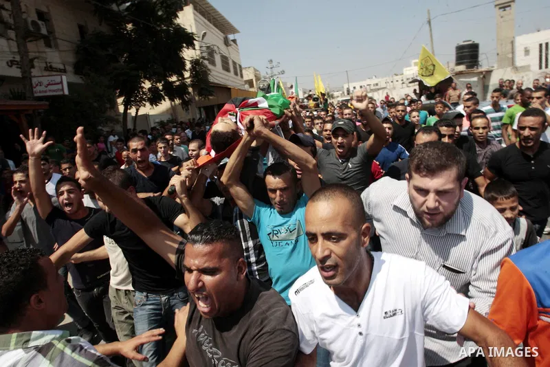Palestinian mourners carry the body of Majd Lahlouh during his funeral at Jenin refugee camp in the West Bank city of Jenin on August 20, 2013. Israeli troops shot dead the Palestinian youth and wounded two others during...