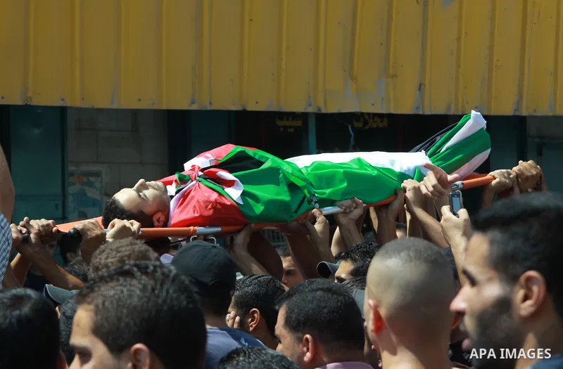 Palestinian mourners carry the body of Majd Lahlouh during his funeral at Jenin refugee camp in the West Bank city of Jenin on August 20, 2013. Israeli troops shot dead the Palestinian youth and wounded two others during...