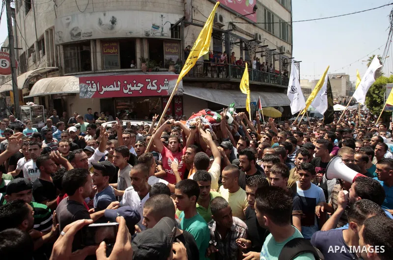 Palestinian mourners carry the body of Majd Lahlouh during his funeral at Jenin refugee camp in the West Bank city of Jenin on August 20, 2013. Israeli troops shot dead the Palestinian youth and wounded two others during...