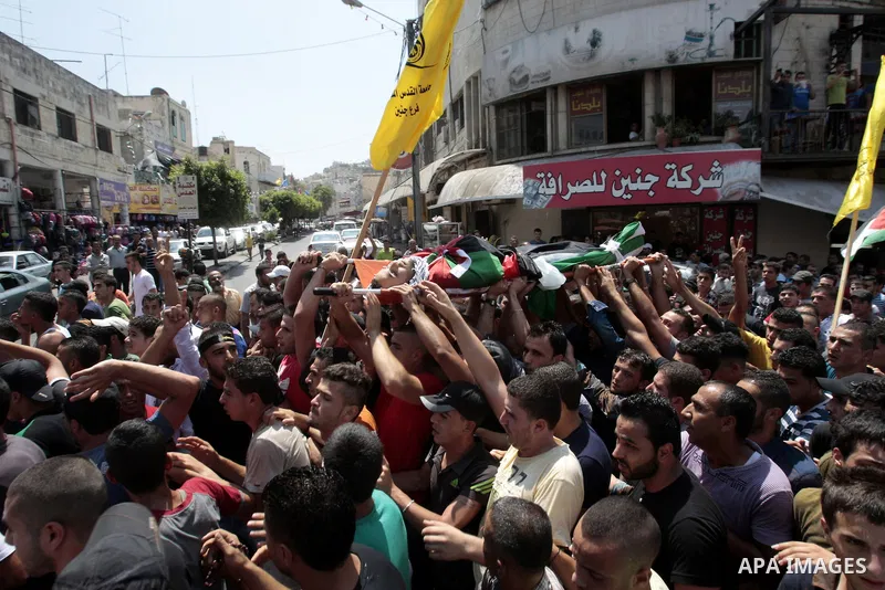 Palestinian mourners carry the body of Majd Lahlouh during his funeral at Jenin refugee camp in the West Bank city of Jenin on August 20, 2013. Israeli troops shot dead the Palestinian youth and wounded two others during...