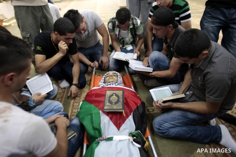 Palestinians mourn over the body of Majd Lahlouh during his funeral at Jenin refugee camp in the West Bank city of Jenin on August 20, 2013. Israeli troops shot dead the Palestinian youth and wounded two others during an...