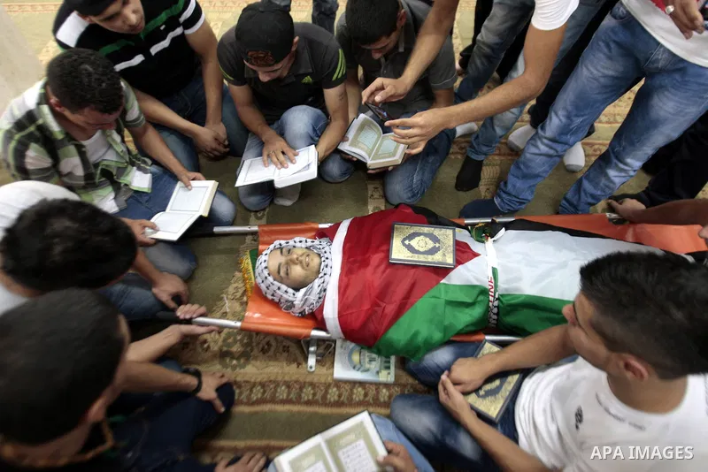 Palestinians mourn over the body of Majd Lahlouh during his funeral at Jenin refugee camp in the West Bank city of Jenin on August 20, 2013. Israeli troops shot dead the Palestinian youth and wounded two others during an...