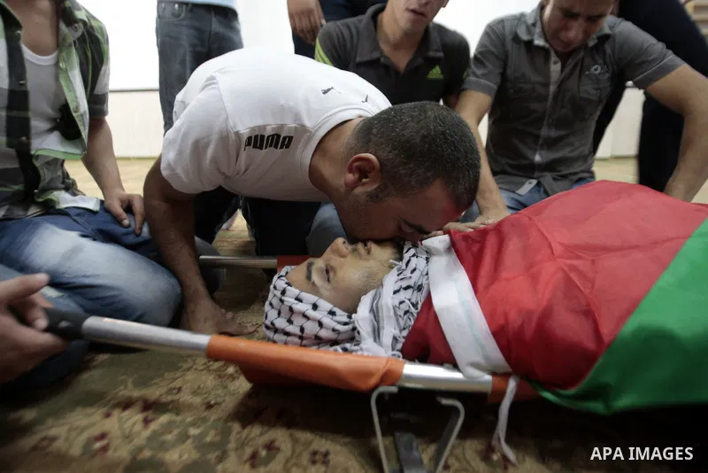 Palestinians mourn over the body of Majd Lahlouh during his funeral at Jenin refugee camp in the West Bank city of Jenin on August 20, 2013. Israeli troops shot dead the Palestinian youth and wounded two others during an...
