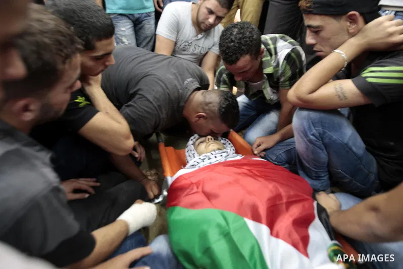 Palestinians mourn over the body of Majd Lahlouh during his funeral at Jenin refugee camp in the West Bank city of Jenin on August 20, 2013. Israeli troops shot dead the Palestinian youth and wounded two others during an...