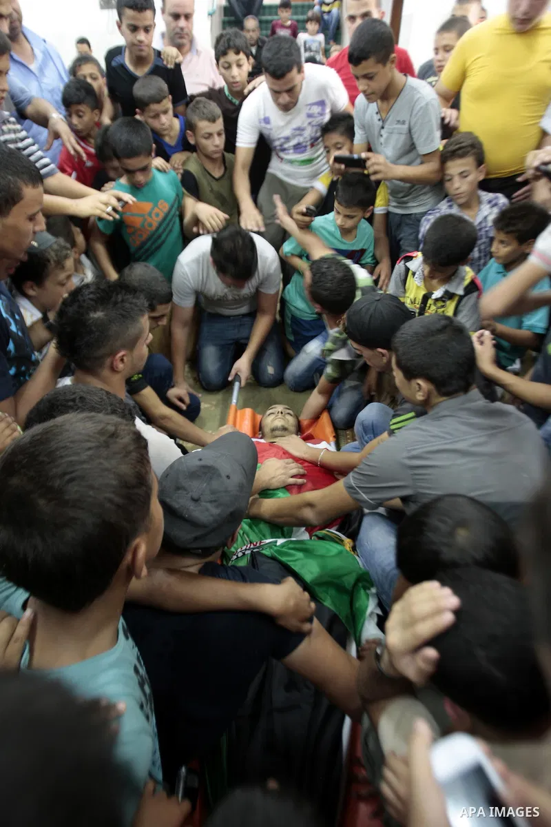 Palestinians mourn over the body of Majd Lahlouh during his funeral at Jenin refugee camp in the West Bank city of Jenin on August 20, 2013. Israeli troops shot dead the Palestinian youth and wounded two others during an...