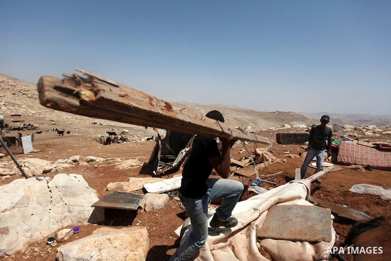 Palestinian Bedouins search in the rubble of their damaged tents after it was dismantled by Israeli bulldozers under the pretext of building without permits at al-Baq'a camp near the West Bank city of Jericho, Aug 20, 20...