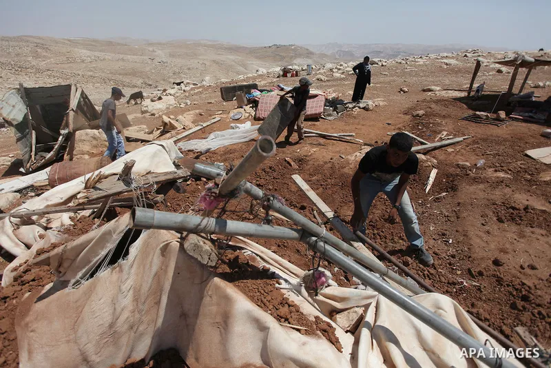 Palestinian Bedouins search in the rubble of their damaged tents after it was dismantled by Israeli bulldozers under the pretext of building without permits at al-Baq'a camp near the West Bank city of Jericho, Aug 20, 20...