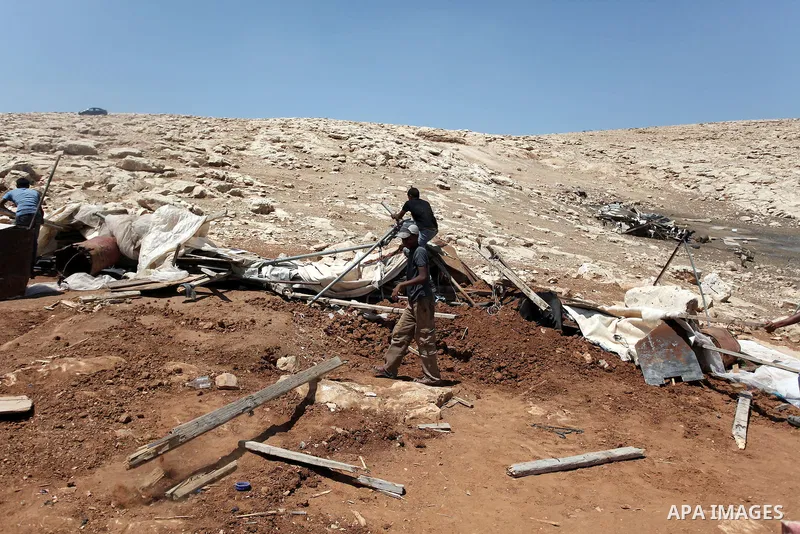 Palestinian Bedouins search in the rubble of their damaged tents after it was dismantled by Israeli bulldozers under the pretext of building without permits at al-Baq'a camp near the West Bank city of Jericho, Aug 20, 20...