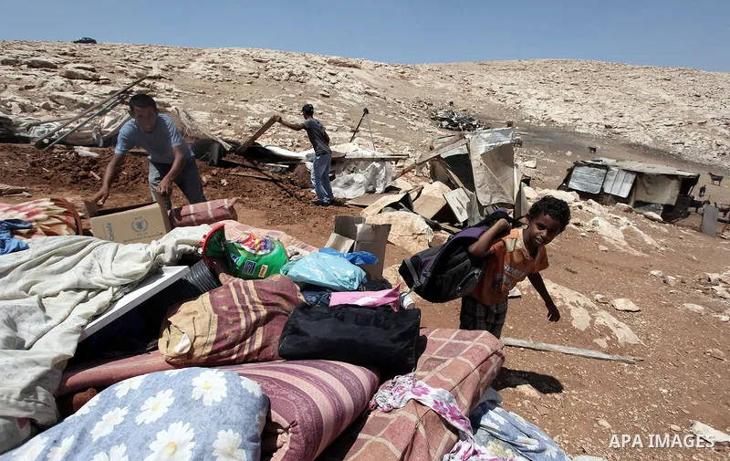 Palestinian Bedouins search in the rubble of their damaged tents after it was dismantled by Israeli bulldozers under the pretext of building without permits at al-Baq'a camp near the West Bank city of Jericho, Aug 20, 20...