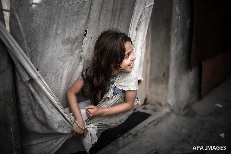 A picture taken on July 31, 2013 shows a Palestinian girl playing outside her family home in Jabalia refugee camp northern Gaza Strip. Photo by Mahmoud Hamda